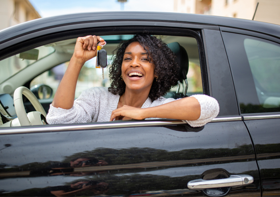 Young woman in car showing keys Young woman in car showing keys